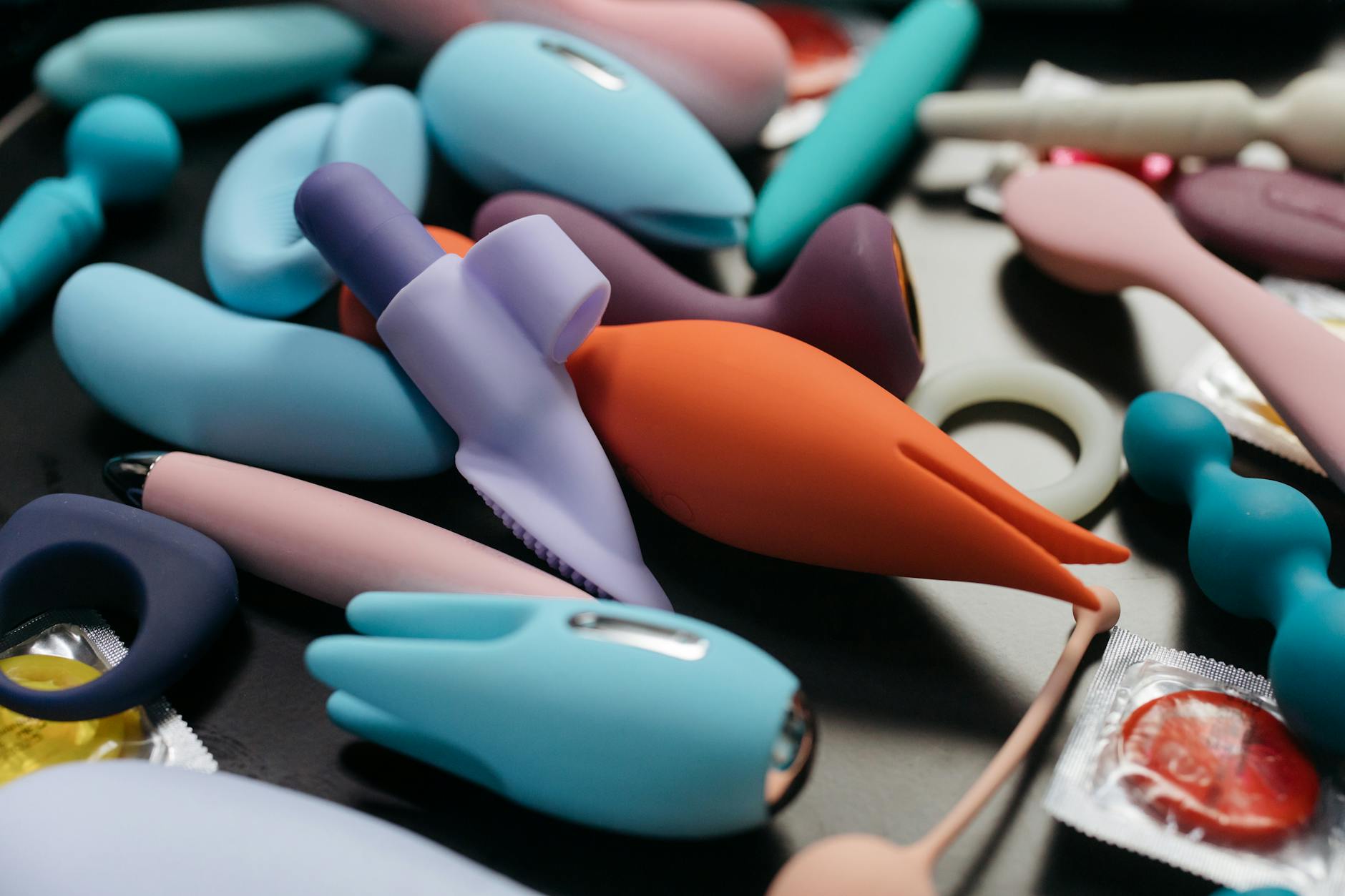 An array of vibrant adult toys including clitoral vibrators and pleasure devices in a close-up view