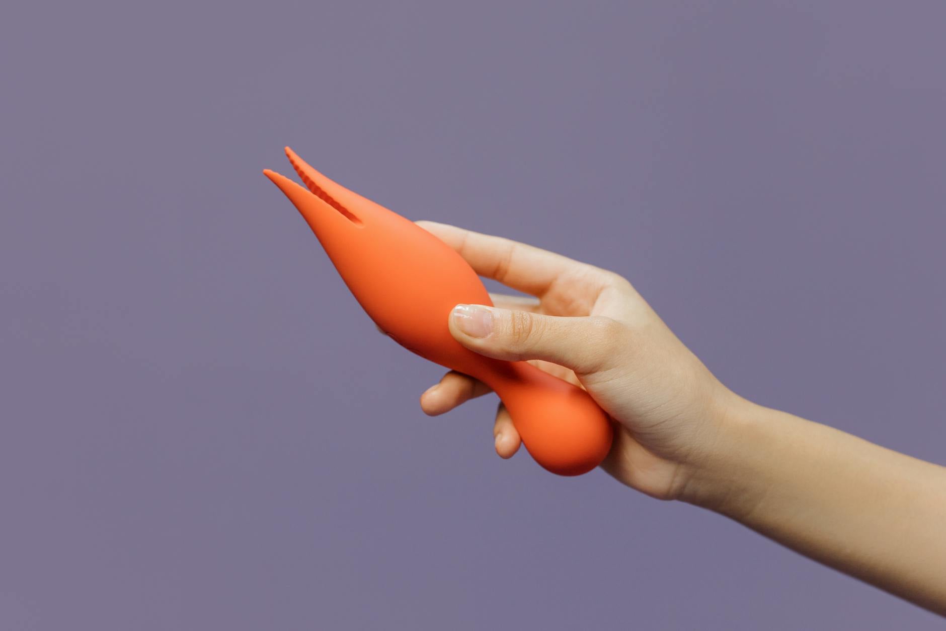 Close-up of a hand holding a lemon-colored vibrator against a purple backdrop, symbolizing the journey back to pleasure after medication.